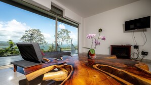 Un salon moderne avec une grande table basse en bois, un canapé confortable et un téléviseur fixé au mur.