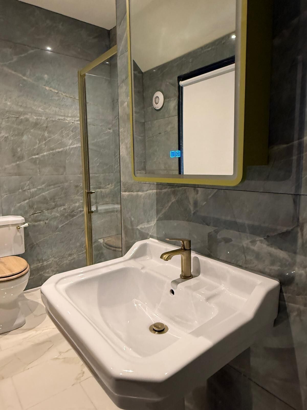 A bathroom with a white sink, a toilet, and a shower area.