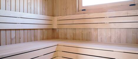 Una sala de sauna con bancos de madera y una ventana.