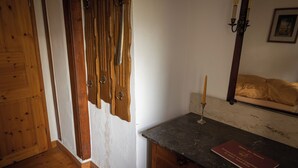 Ein Zimmer mit Holztüren, einer Marmorplatte und einem Kerzenhalter.