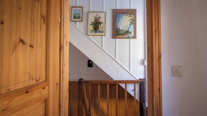 Eine Holztreppe mit weißen Wänden und drei gerahmten Kunstwerken.