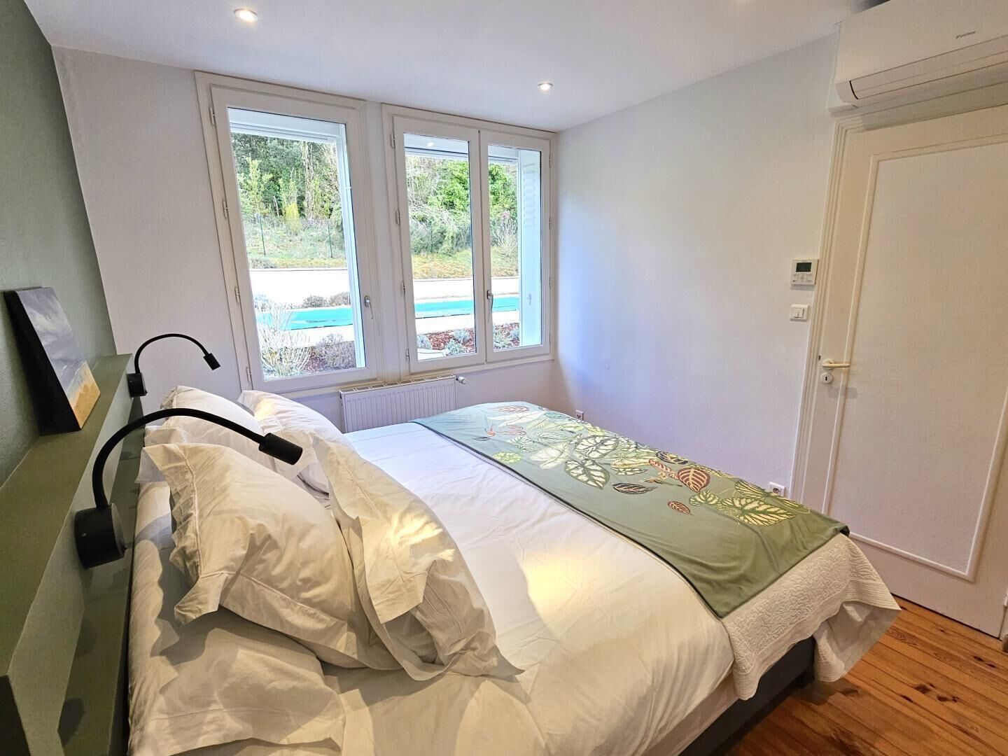 Un dormitorio con cama, ventana y puerta.