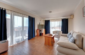Apartamento família, vista para o mar | Área de estar | TV