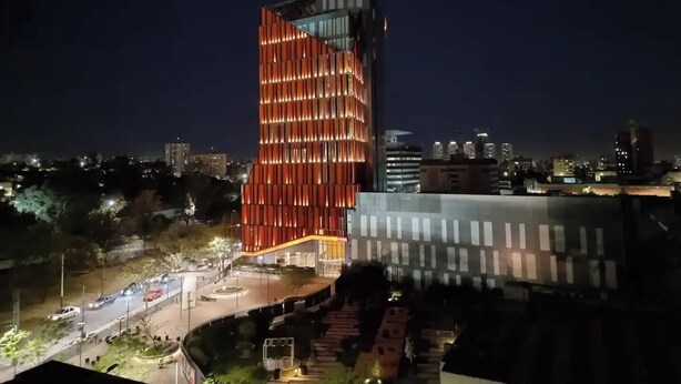 A modern building with a unique angular design, featuring a prominent red-lit facade. - EXTRAORDINARY LOFT in Cordoba 22C (Córdoba)