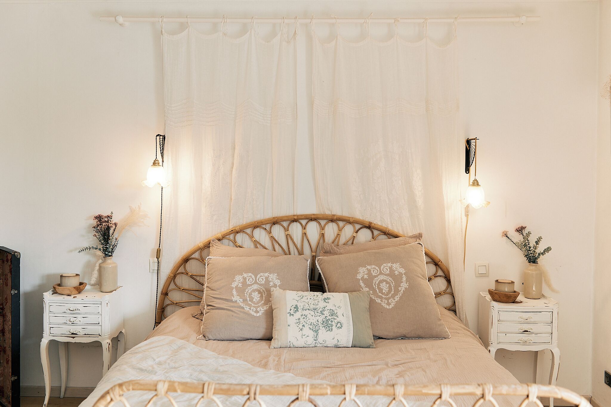 Ein Schlafzimmer mit einem Bett, zwei Nachttischen und einem Kopfteil.