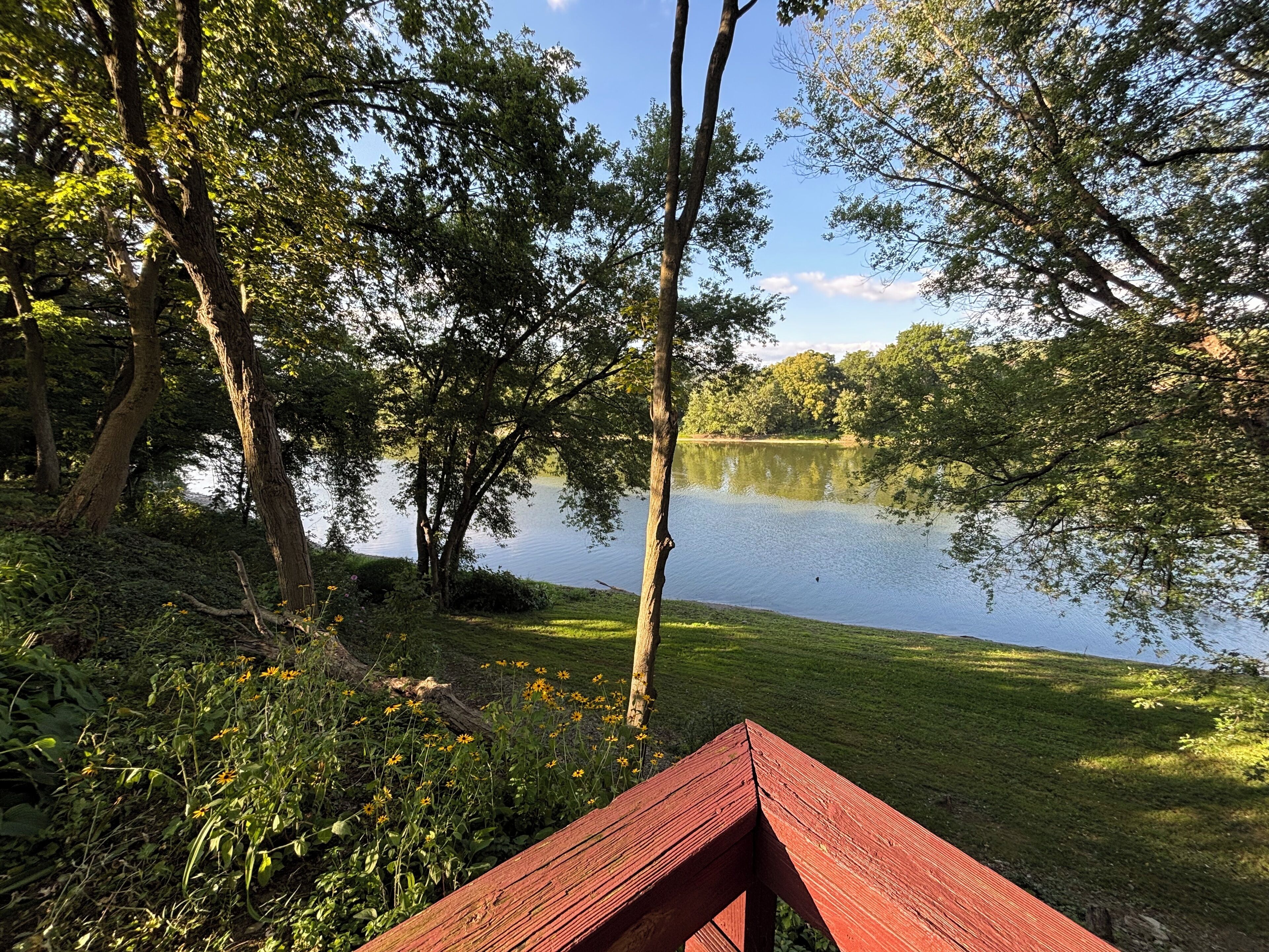 Une vue sur le lac, avec un banc en bois et une végétation luxuriante.