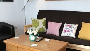 A wooden coffee table with a vase of flowers, a remote control, and a small card on it. - The Woodfarm Lodge - 3 Bedroom House With Parking (Oxford)