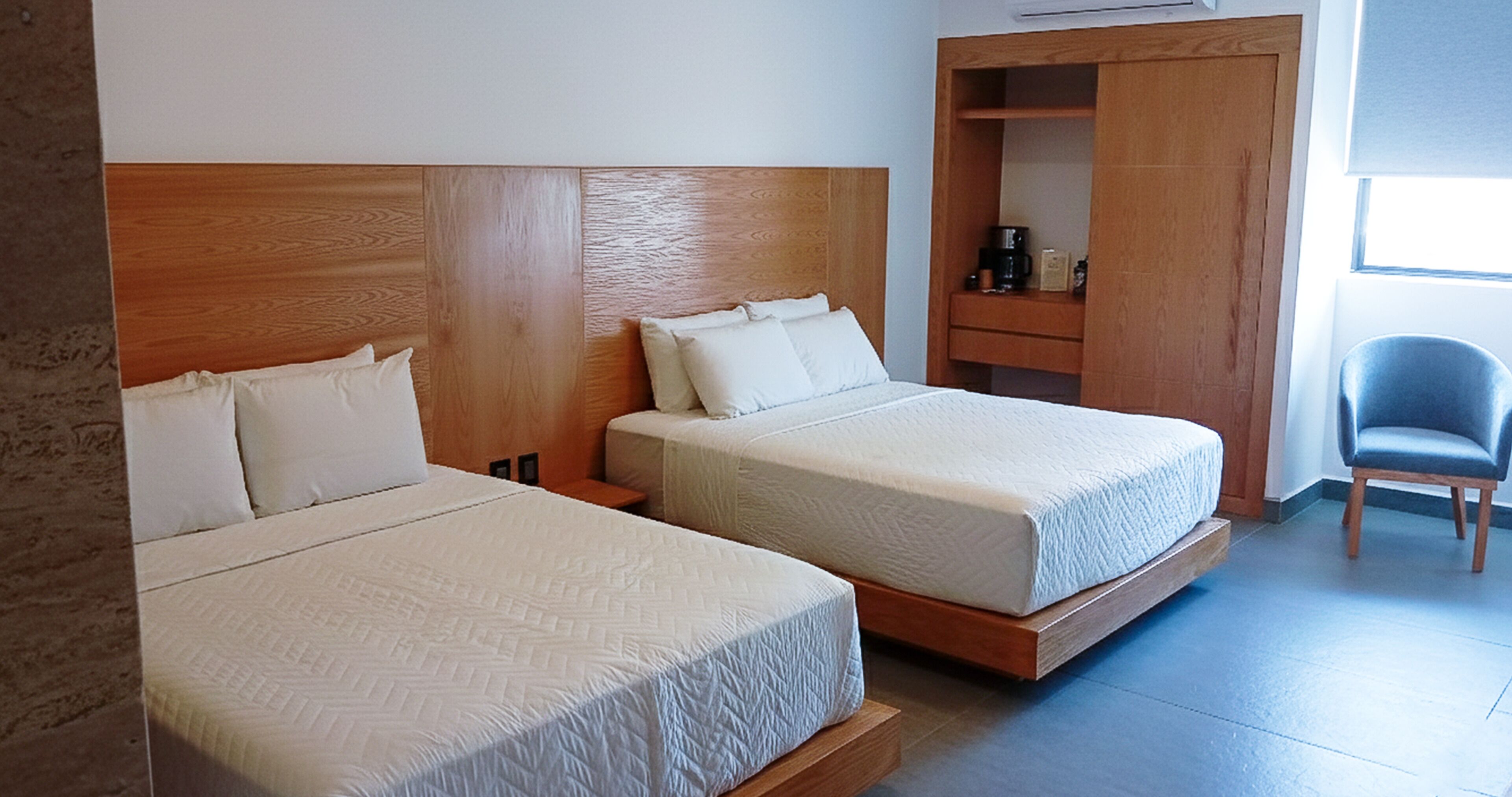 Two single beds with wooden headboards in a hotel room.