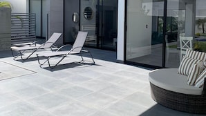 Un patio extérieur moderne avec des fauteuils de détente et un canapé en osier.