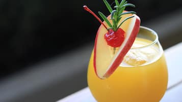 Un cóctel con una rodaja de manzana y una cereza como adorno.