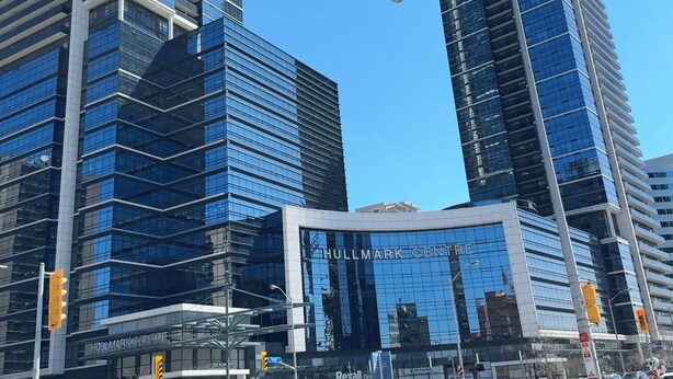 A modern building with reflective glass windows and a sign reading "HULLMARK CENTRE".