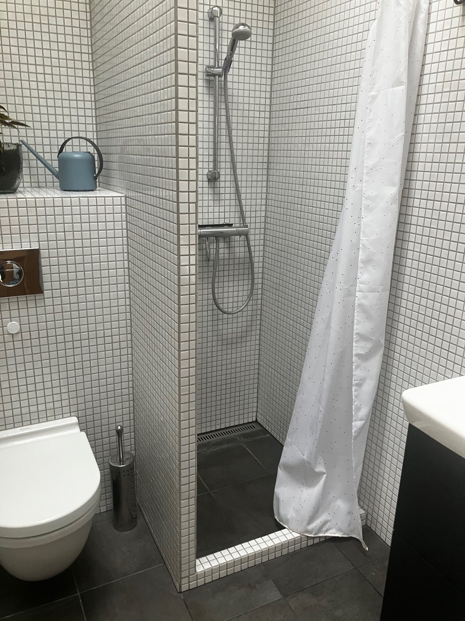 Un baño con cabina de ducha, inodoro y lavabo.