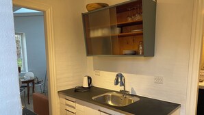 A compact kitchen with a sink, a kettle, and a small countertop. - Husmandsvej 5 (Odder)