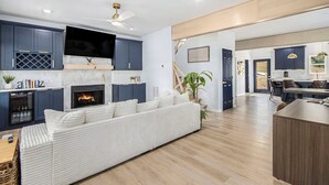 Ein großzügiger Wohnbereich mit Kamin, einer Couch und einem Essbereich mit Holztisch und Stühlen.