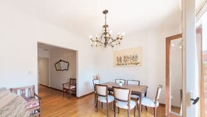 A dining area with a wooden table and chairs, a chandelier, and a painting on the wall. - PH IN PALERMO SOHO WITH TWO SPECTACULAR TERRACES BBQ AND FAMILY ROOM (Buenos Aires)