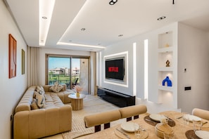Uma sala de estar moderna com sofá, mesa de centro e área de jantar.