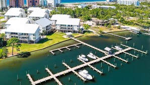 A marina with multiple docks and boats, surrounded by residential buildings and a beach.