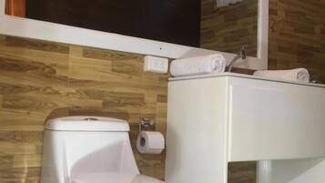 A modern bathroom with a toilet, sink, and mirror.