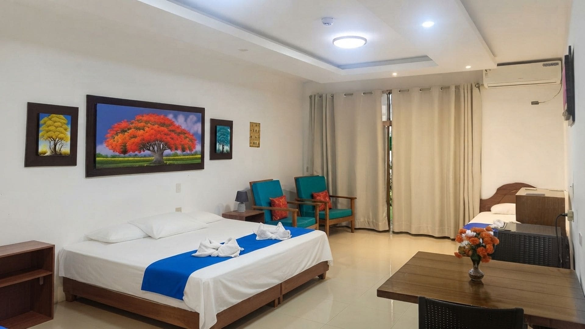 Une chambre d’hôtel avec un lit, deux chaises, une table et un vase de fleurs.