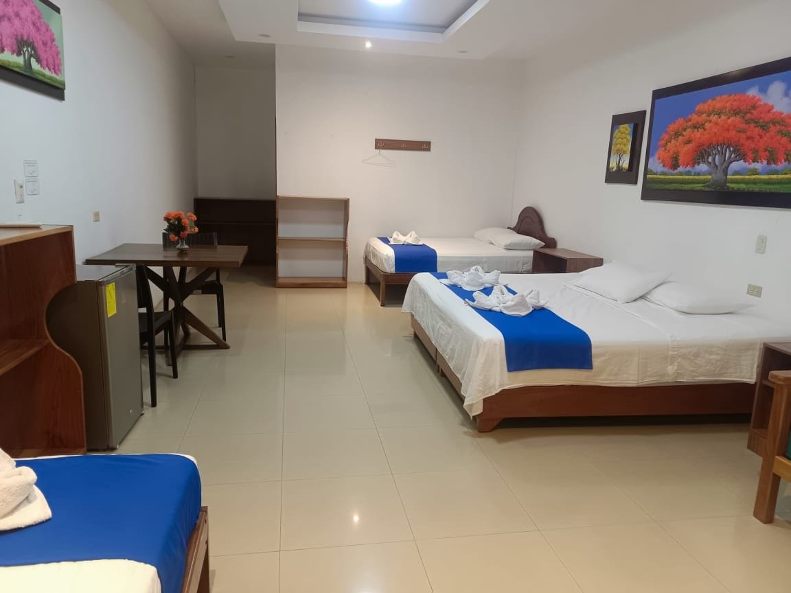 Una habitación de hotel con dos camas, un escritorio, una silla y un armario.