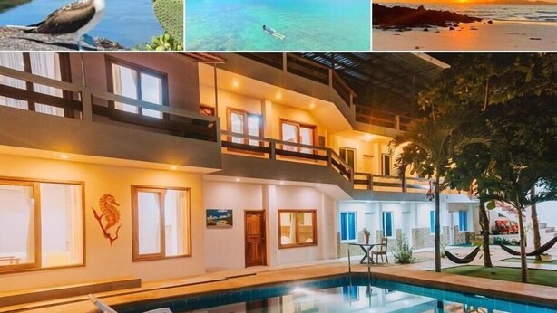 Un hotel de dos pisos con piscina, balcón y vista al mar.