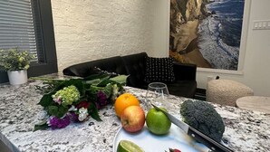 Un comptoir de cuisine avec une assiette de fruits, un couteau et une plante en pot.