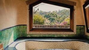 A room with a view of a garden through a window, a tiled floor, and a wooden ceiling. - EL EQUIMITE HOTEL BOUTIQUE (Coatepec)