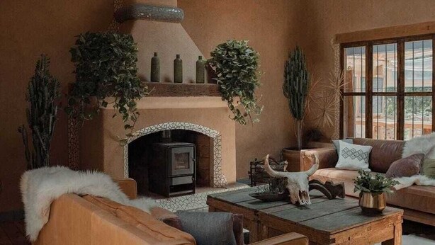 A cozy living room with a fireplace, wooden furniture, and large windows. - EL EQUIMITE HOTEL BOUTIQUE (Coatepec)
