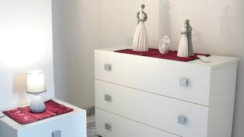 A white dresser with drawers and a lamp on a side table.