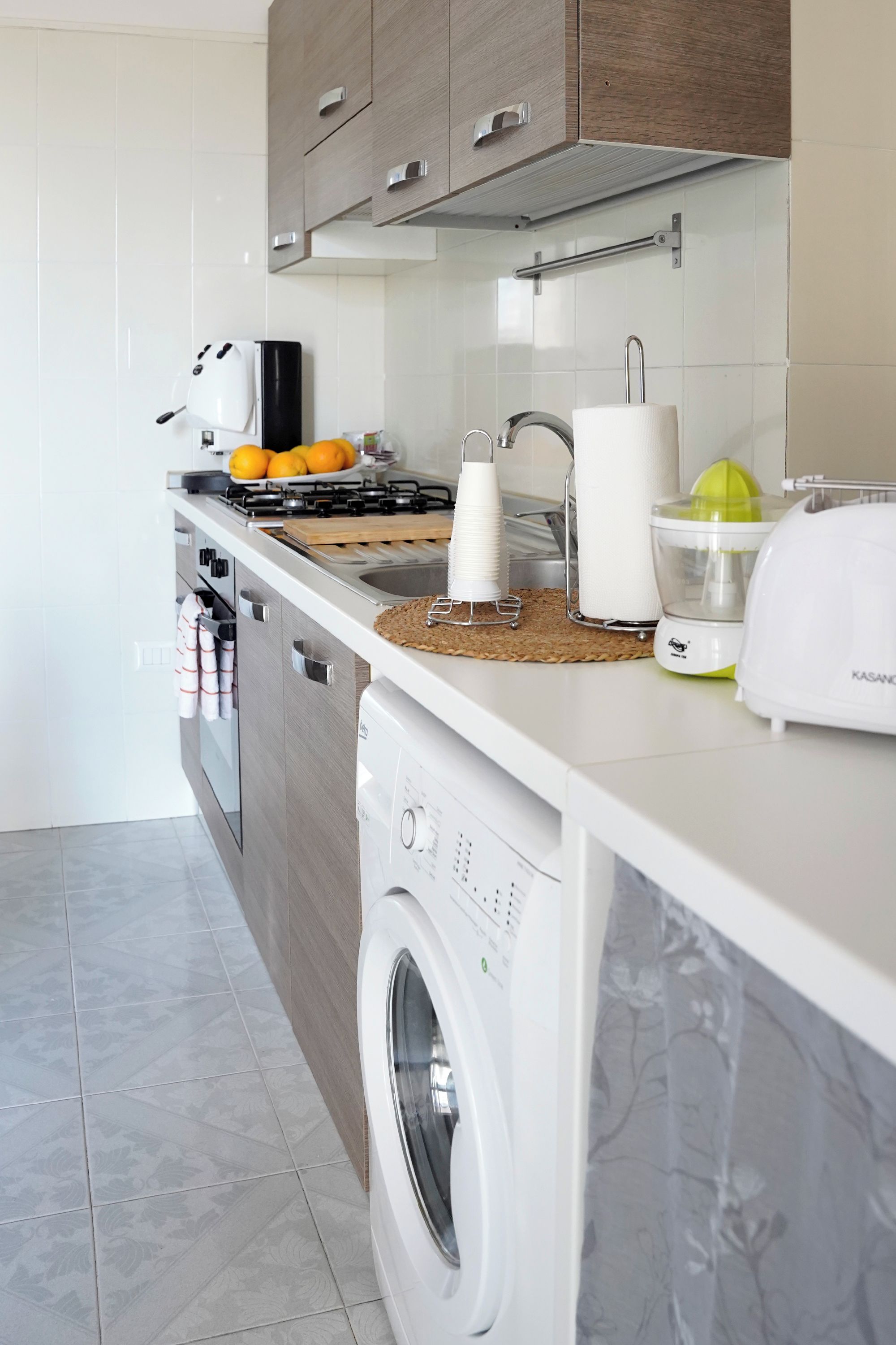 A modern kitchen with a built-in washing machine, a stove, and a sink.