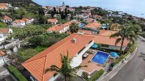 Un quartiere residenziale con case, una piscina e vista sul mare.