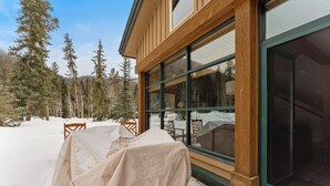 A wooden building with large windows, a covered outdoor seating area, and snow-covered ground. - St8716-3 (Keystone)