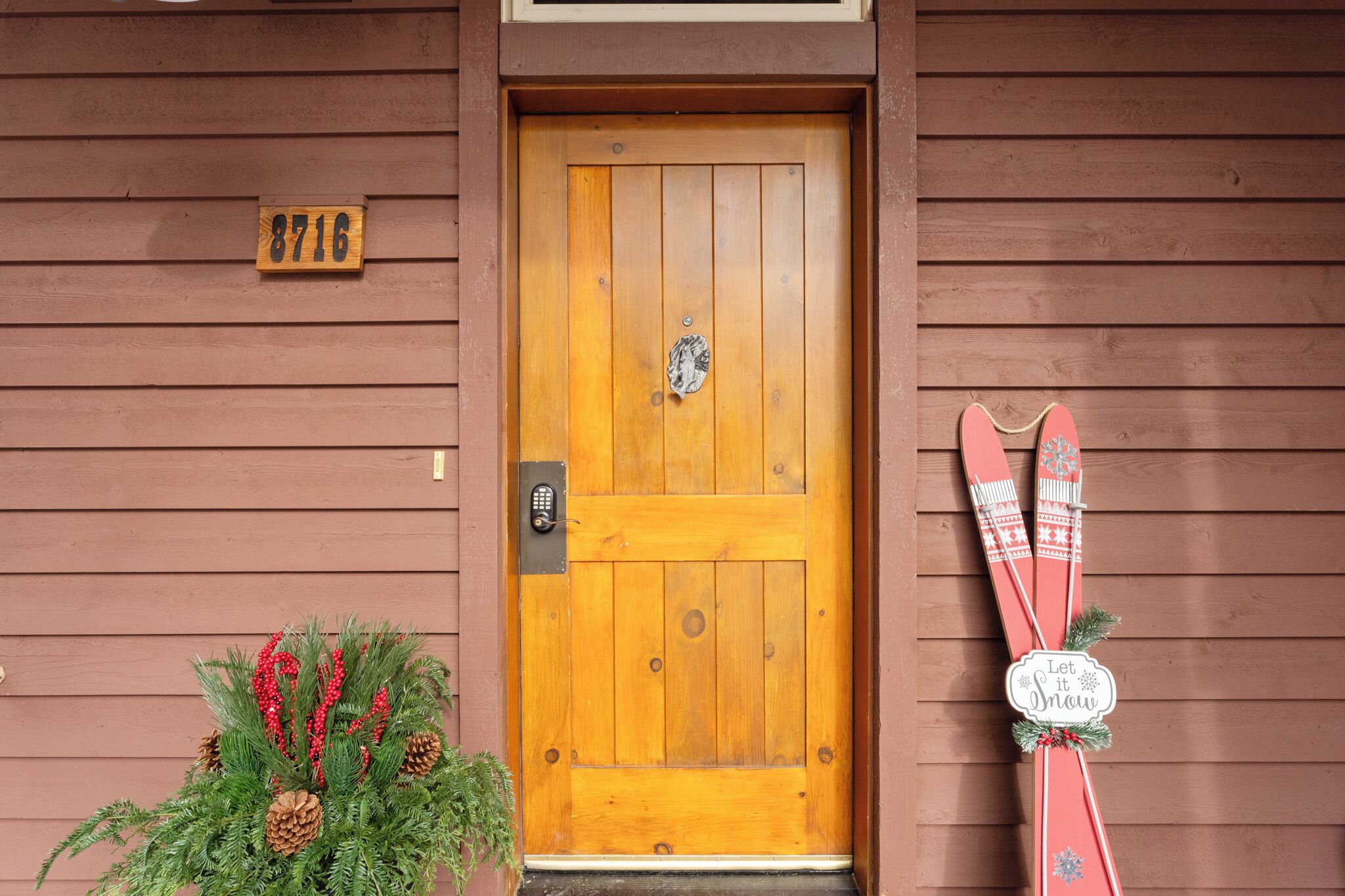 A wooden door with a number plaque, a keyhole, and a small mailbox.