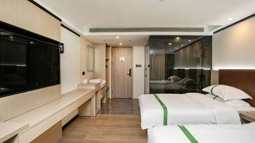 Una habitación de hotel con cama, mesita de noche, televisor y baño con espejo y lavamanos.