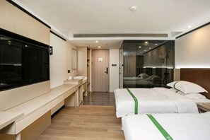 A hotel room with a bed, bedside table, TV, and a bathroom with a mirror and sink. - GreenTree Inn (Shanghai Gongfu Xincun Metro Station) (Shanghai)