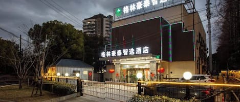 A hotel with a prominent sign, a gated entrance, and a well-lit facade.