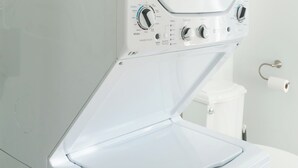 Eine moderne, an der Wand befestigte Waschmaschine mit einer Bedienkonsole und verschiedenen Einstellungen.