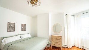 Ein Schlafzimmer mit einem Bett, einer hölzernen Kommode und einem Spiegel.