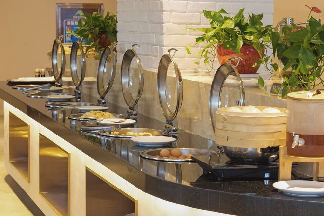 A buffet setup with multiple food stations, including a hot pot and a variety of dishes.