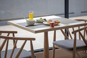 A breakfast table with a bowl, a glass of juice, a plate of food, and a cup. - Wuyishan Mushi Time Hotel (Impression Dahongpao Store) (Wuyishan)