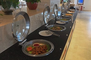 A buffet setup with various dishes and utensils. - Wuyishan Mushi Time Hotel (Impression Dahongpao Store) (Wuyishan)