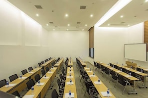A conference room with long tables, chairs, and a whiteboard. - Wuyishan Mushi Time Hotel (Impression Dahongpao Store) (Wuyishan)