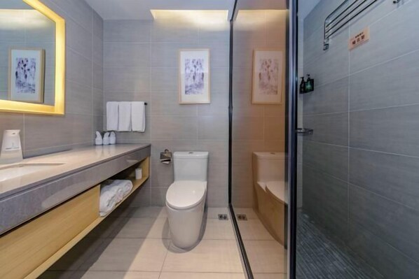 Ein modernes Badezimmer mit Toilette, Waschbecken und Duschbereich.