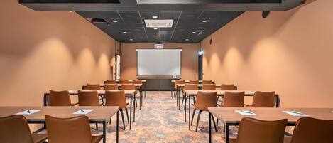 A conference room with a large whiteboard, multiple tables, and chairs arranged for meetings.