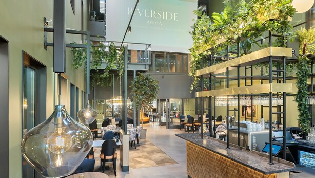 A modern interior with a bar area, seating, and a large screen displaying 'RIVERSIDE AVESTA'. - Hotel Riverside Avesta, BW Signature Collection (Avesta)