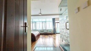 Un couloir doté d’un plancher en bois, d’un canapé et d’une cloison en verre.