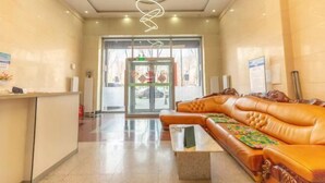 Un espace d’accueil comprenant un comptoir de réception, un canapé et une table basse.