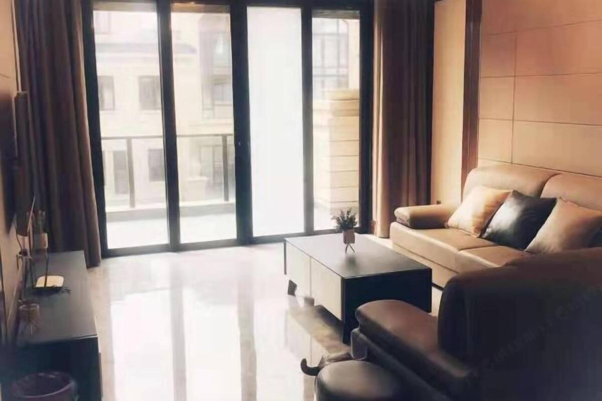 Una sala de estar moderna con un sofá, una mesa de centro y vistas a través de puertas de cristal grandes.