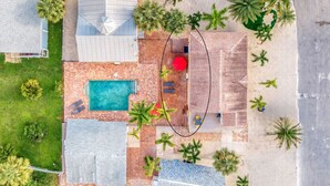 An aerial view of a property with a swimming pool, multiple buildings, and palm trees. - Steps to BEACH/POOL/Downtown (Fort Myers Beach)