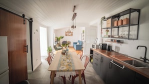 A modern kitchen with a wooden dining table, dark cabinets, and a built-in oven.